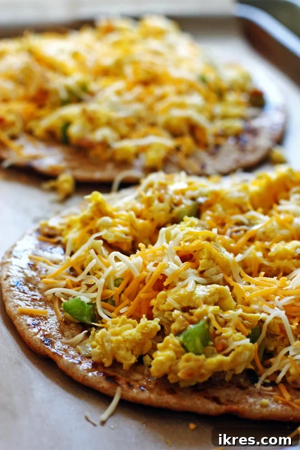 Quick Tortilla Breakfast Pizza 5 Unbaked breakfast pizza with scrambled eggs, ham, and cheese on a tortilla, ready for the oven.