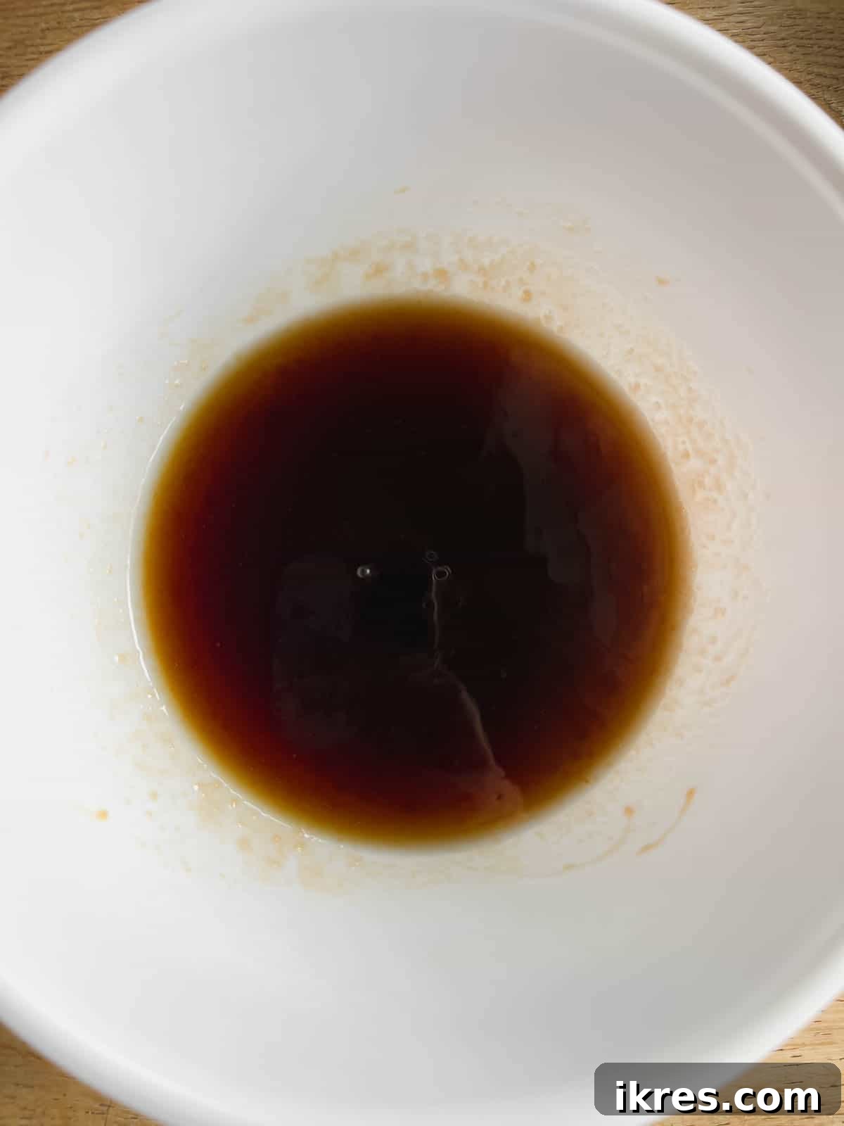 Maple syrup mixture for granola in a separate bowl.