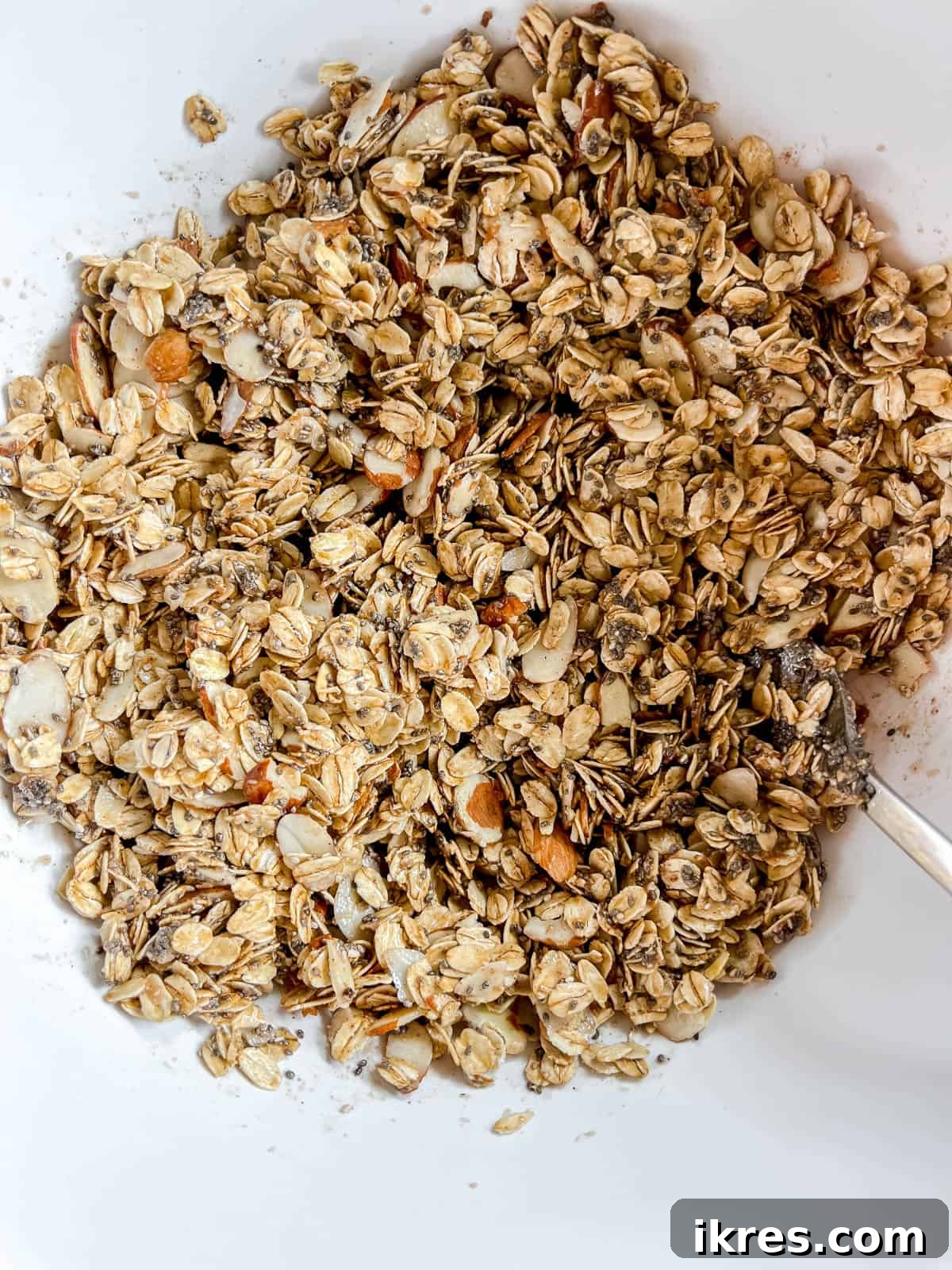 Chia seed granola with maple syrup on top, ready to be mixed.