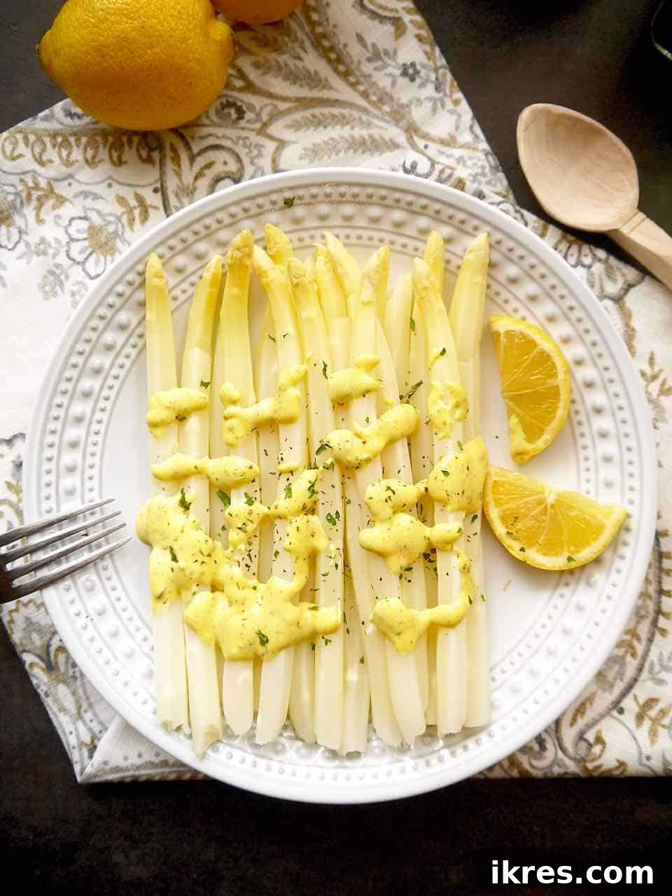 Spring White Asparagus with Provençal Citrus Mustard Dressing 2 Delicate white asparagus spears, perfectly cooked, resting on a white plate and generously coated with a creamy, bright Provençal lemon mustard mayonnaise. Garnished with fresh herbs, showcasing a gourmet side dish.