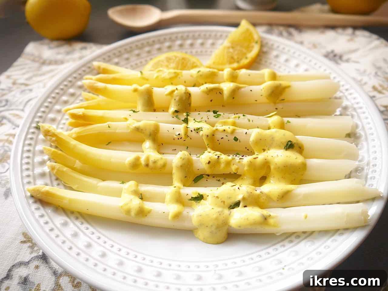 Spring White Asparagus with Provençal Citrus Mustard Dressing 3 Close-up of steamed white asparagus spears beautifully arranged on a serving dish, glistening with a creamy Provençal lemon mustard mayo. The vibrant yellow sauce provides a stunning contrast to the pale asparagus.