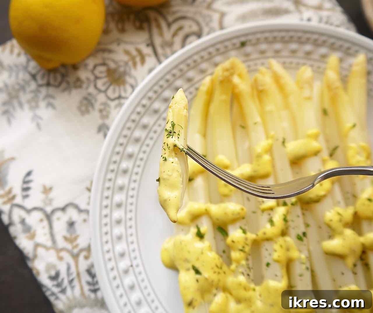 Spring White Asparagus with Provençal Citrus Mustard Dressing 4 A vibrant flat lay of the fresh ingredients needed for the white asparagus recipe, including a bunch of pristine white asparagus, bright yellow lemons, a single egg, a jar of mustard, and a small bowl of herbes de Provence, all artfully arranged on a light background.