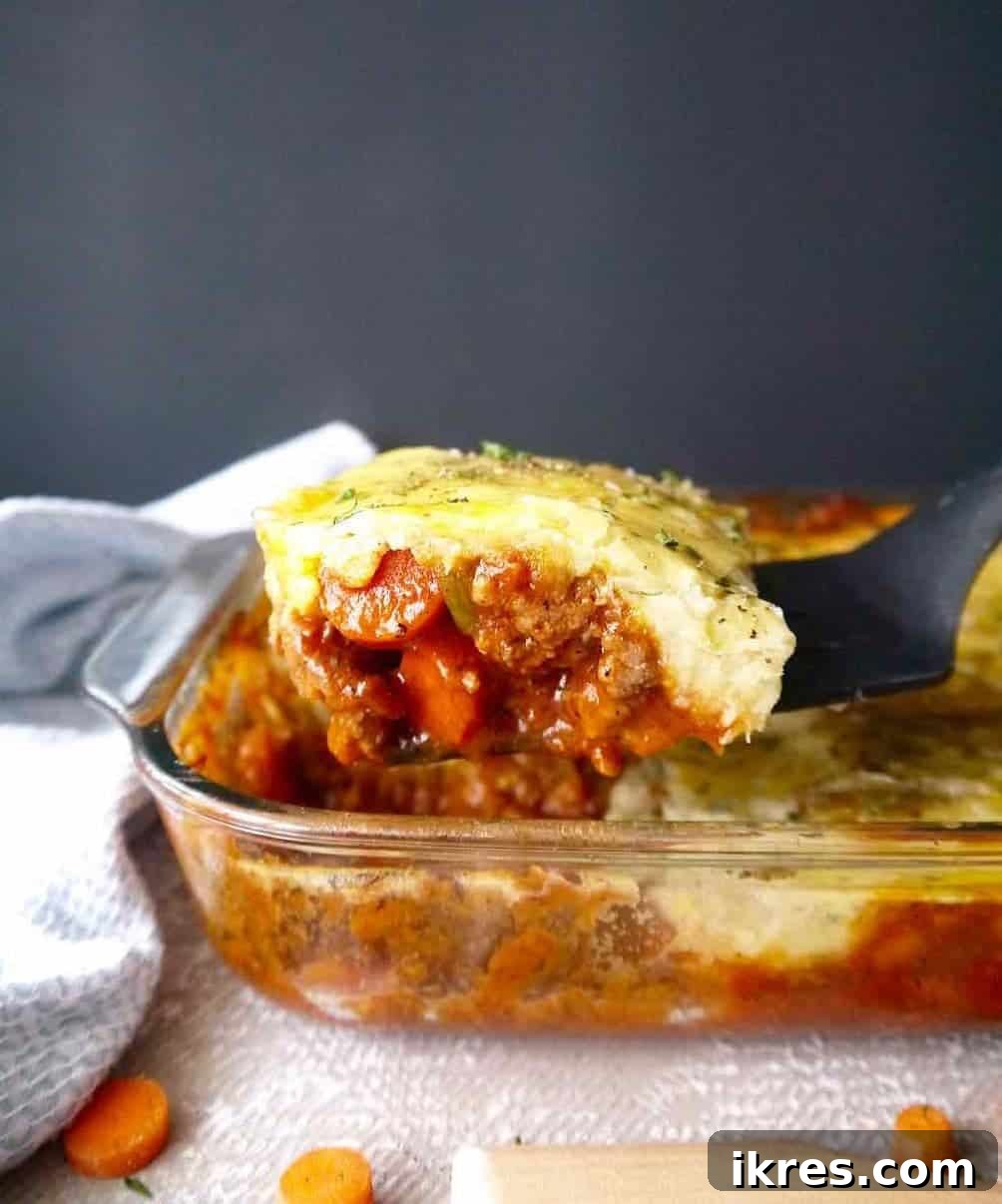 A perfectly cut slice of paleo ground lamb shepherd's pie being served from the pan, showcasing its rich layers.