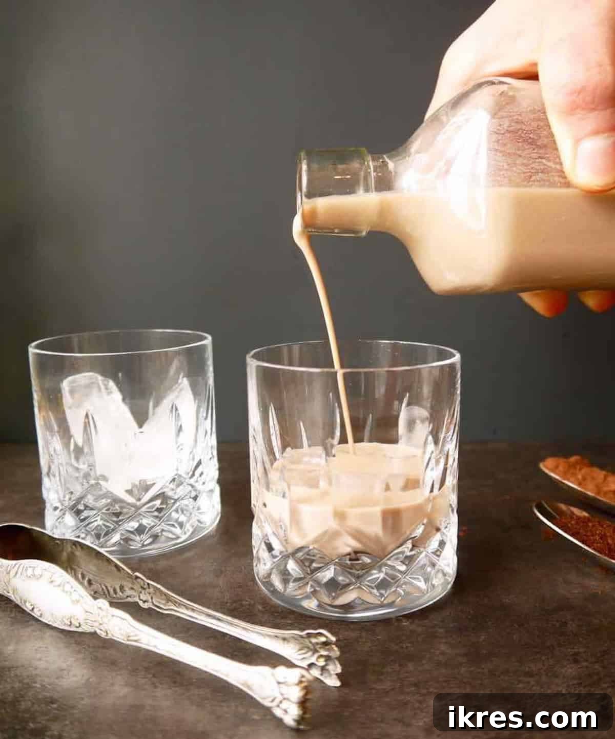 Dairy Free Irish Cream Liqueur From Scratch 7 Dairy-free Irish cream being poured from a bowl into a glass bottle.