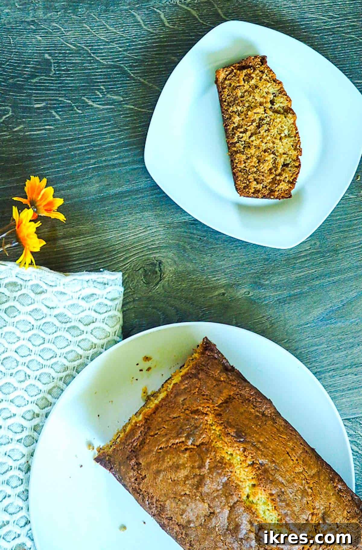 Perfectly Easy Bread Maker Banana Bread 5 A beautiful loaf of bread machine banana bread, golden-brown and perfectly baked, sitting on a white plate with a slice removed, highlighting its moist interior.