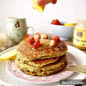 Lemon poppyseed pancakes with strawberries on top.