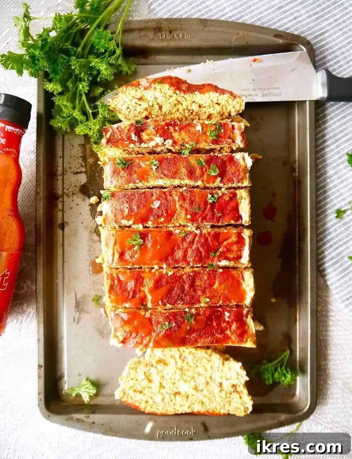 Spicy Buffalo Turkey Meatloaf Paleo Whole30 and Gluten Free 2 A perfectly sliced buffalo turkey meatloaf, showcasing its moist texture and savory glaze, ready to be served from a baking pan.