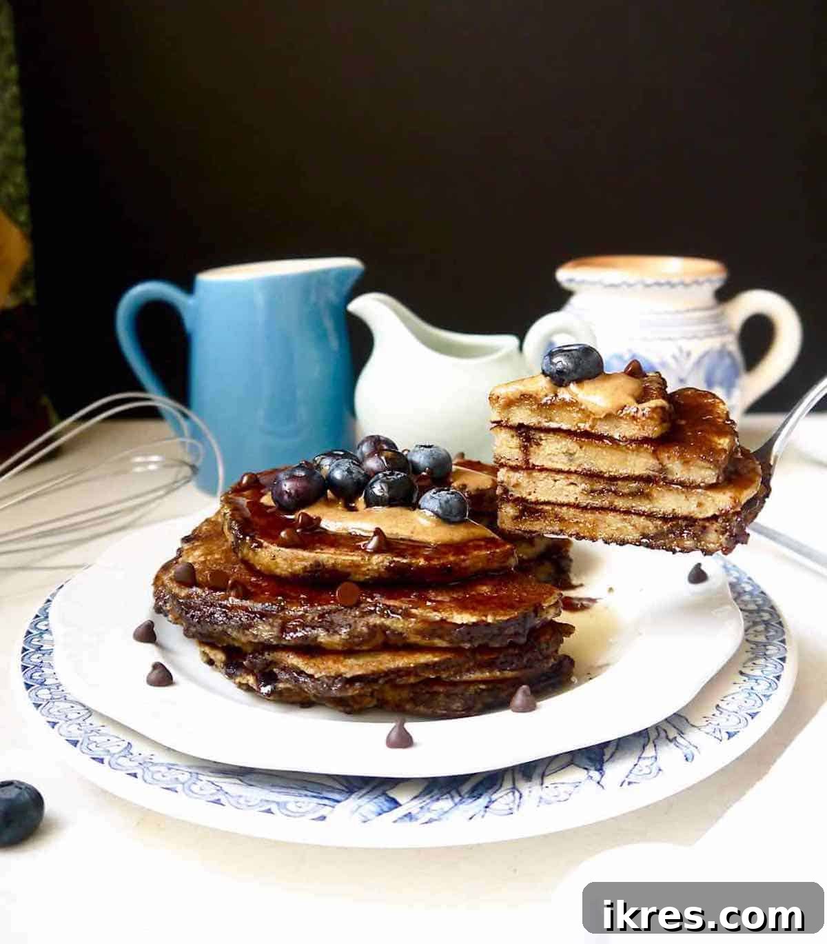 Gluten-free banana pancakes on a fork, showing their fluffy texture.