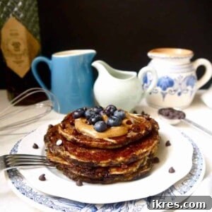Paleo banana pancakes with blueberries and almond butter on top.