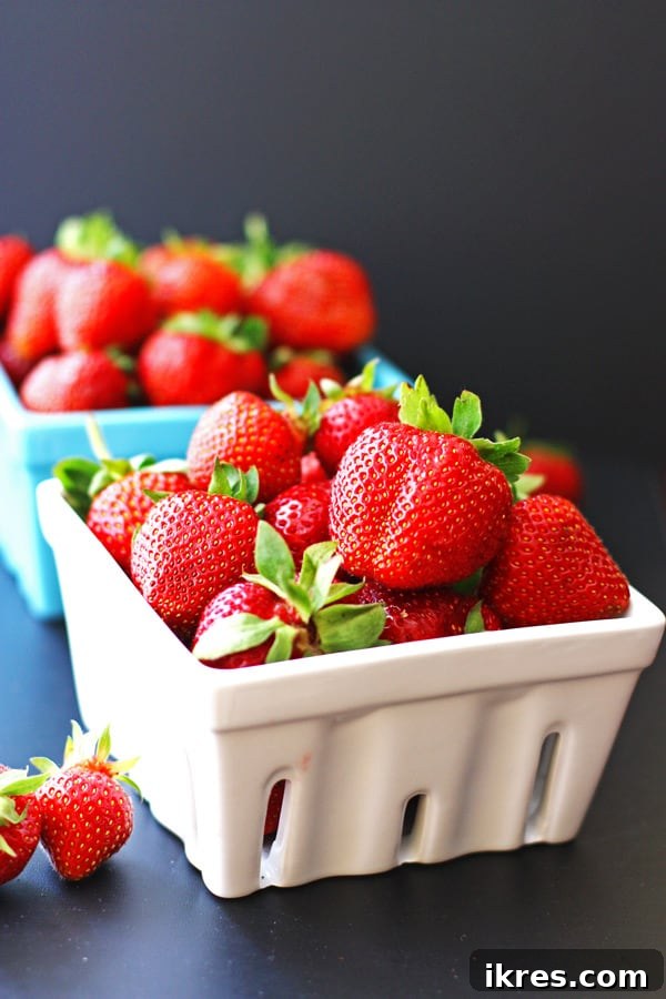 Strawberries in white and blue quart containers