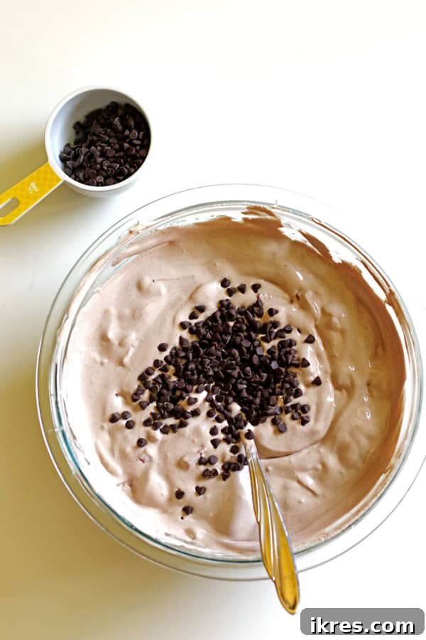 Adding chocolate chips to the ice cream pie mixture