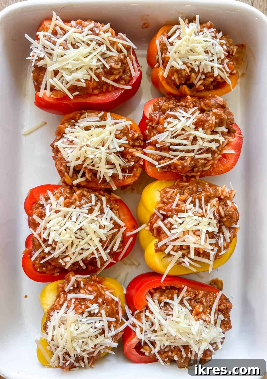 Shredded Parmesan cheese sprinkled over the stuffed bell peppers before baking.