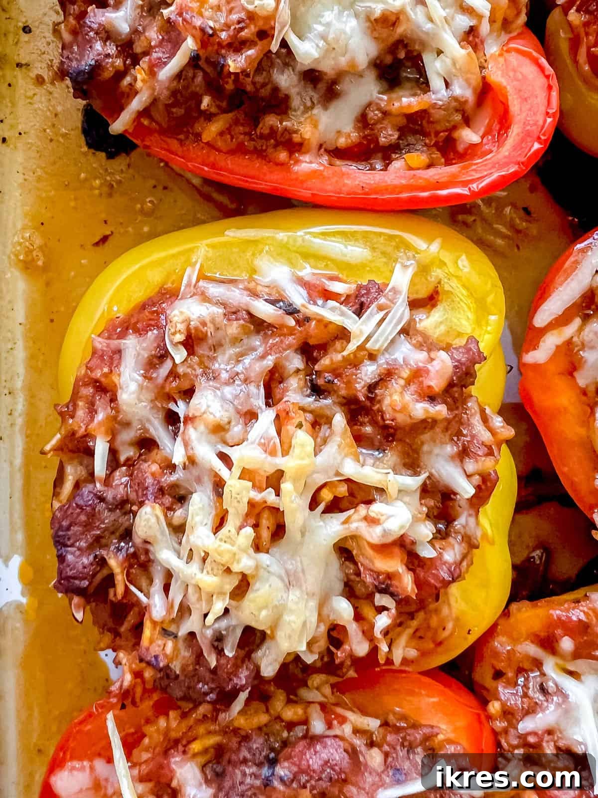 Close-up of a healthy stuffed pepper with ground beef, rice, and melted cheese on top, ready to eat.