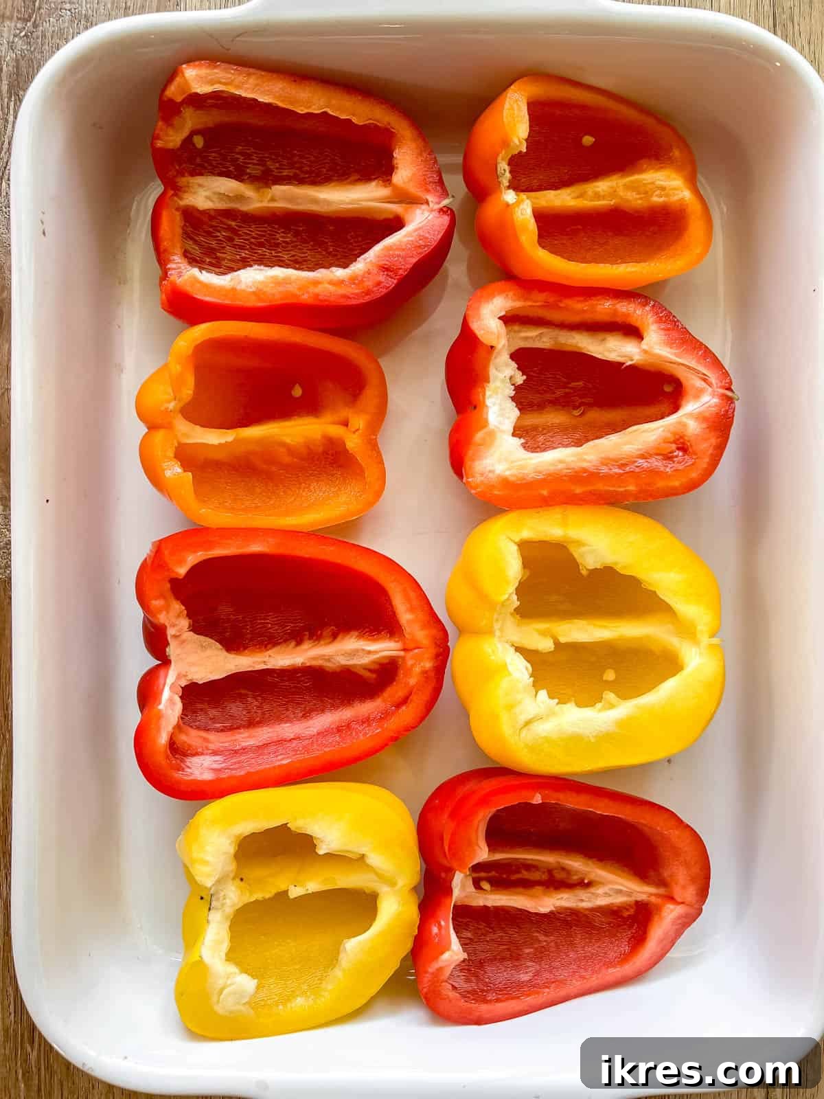 Bell peppers halved lengthwise and placed in a baking pan.