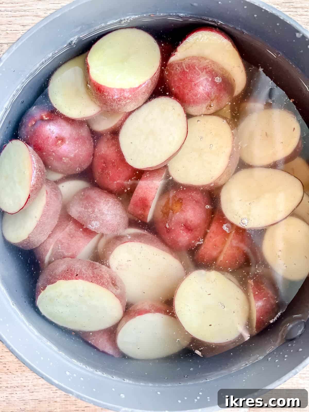 Rustic French Tuna Potato Salad 4 Slices of red potatoes submerged in boiling water in a large pan, cooking until tender.