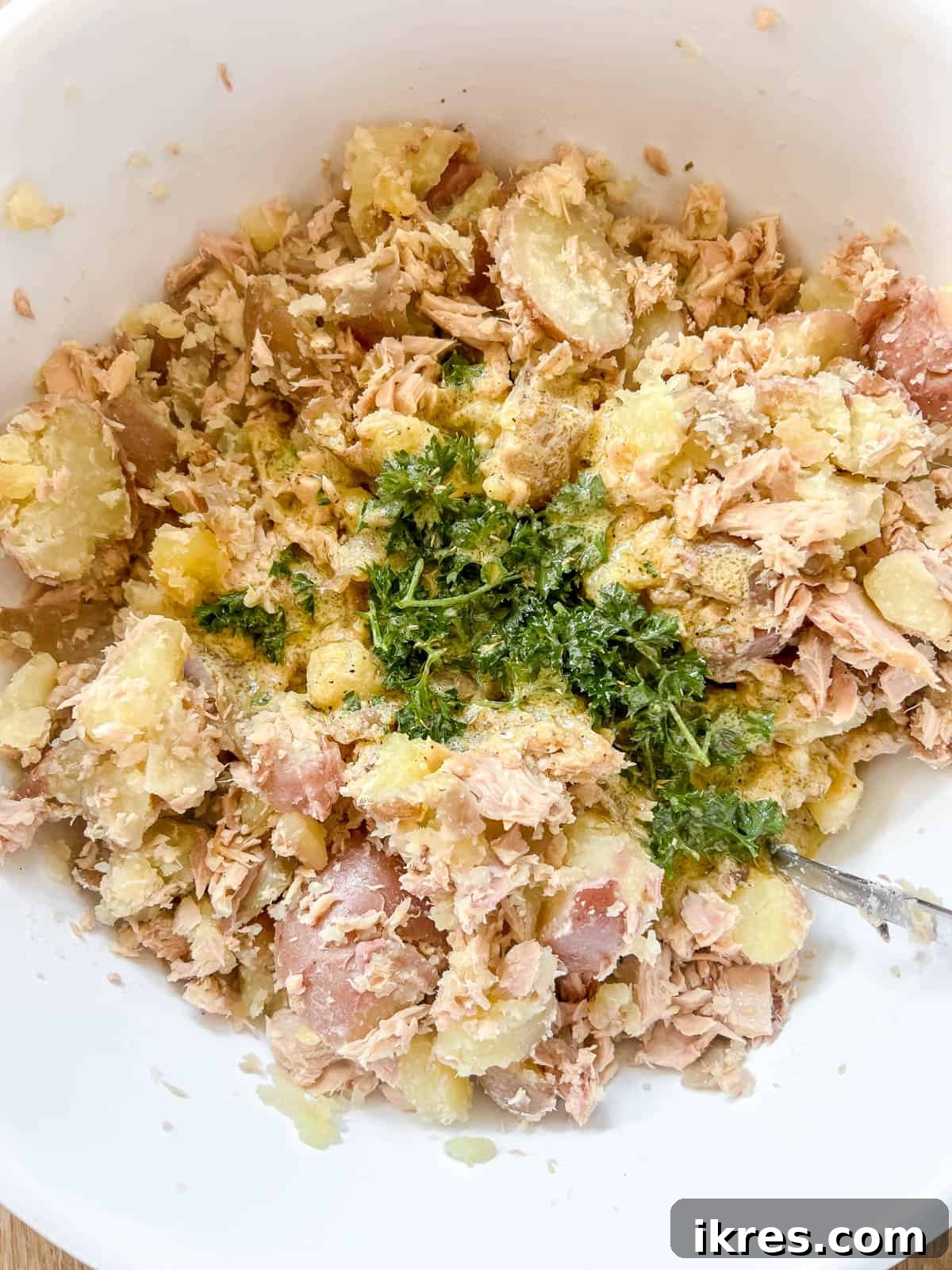 Rustic French Tuna Potato Salad 8 Diced onions and the freshly made French dressing are poured over the tuna and potatoes in the large mixing bowl.