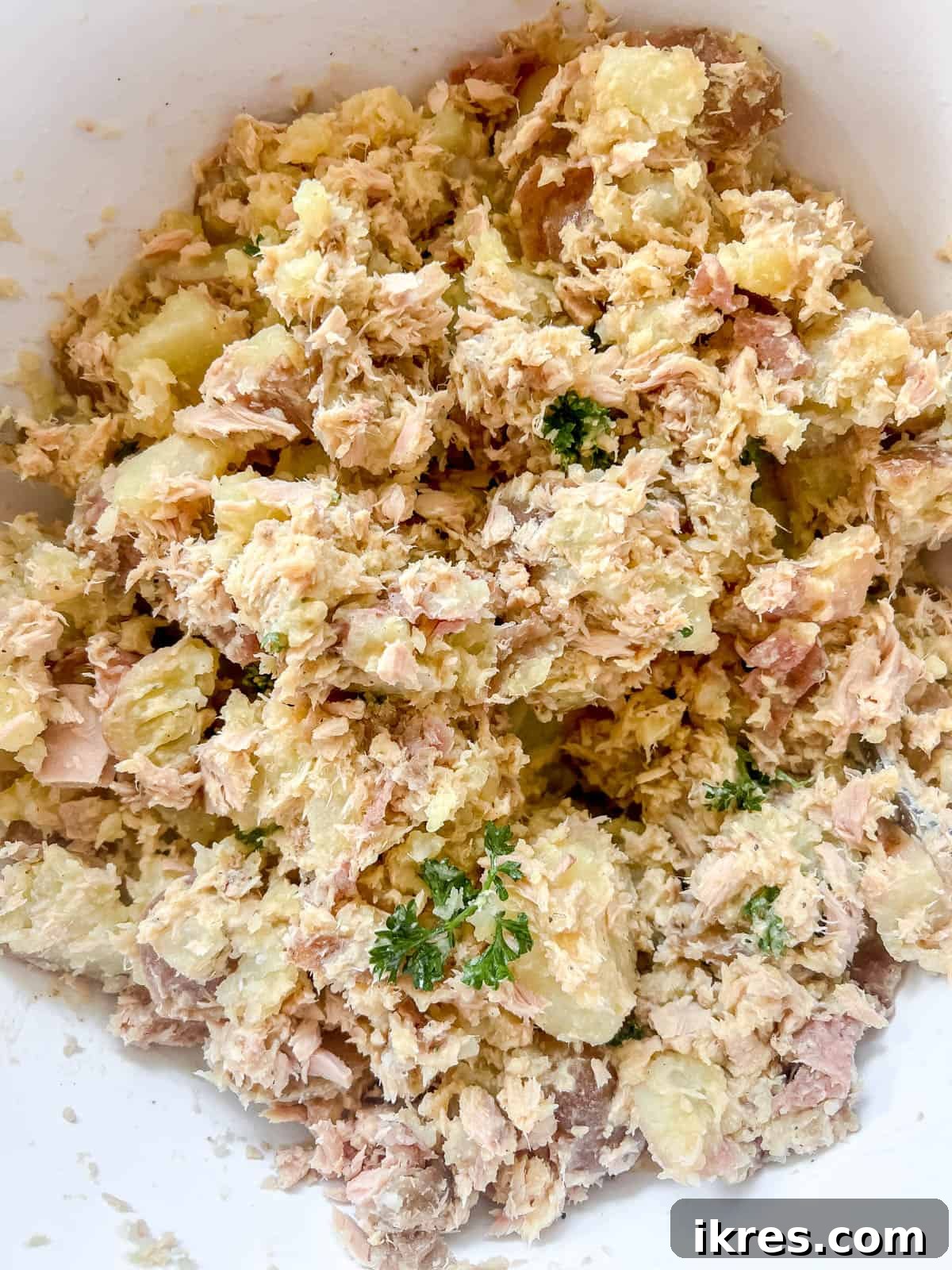 Rustic French Tuna Potato Salad 9 All the ingredients for the French tuna potato salad thoroughly mixed together in a large bowl, showing an even distribution of tuna, potatoes, and dressing.
