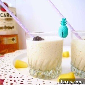 All Natural Piña Coladas in a glass with a pineapple wedge.
