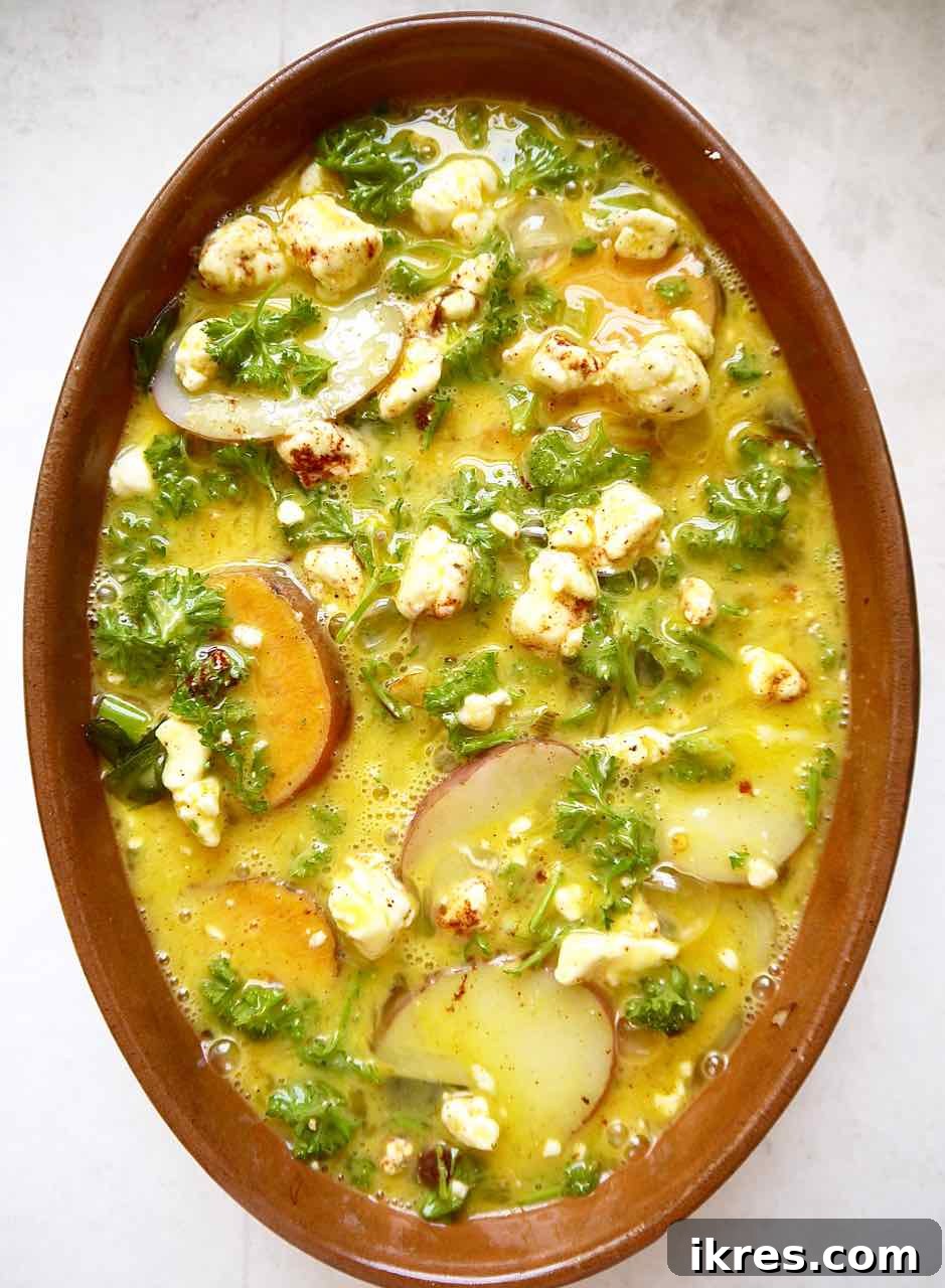 Pouring egg mixture over layered potatoes for baking