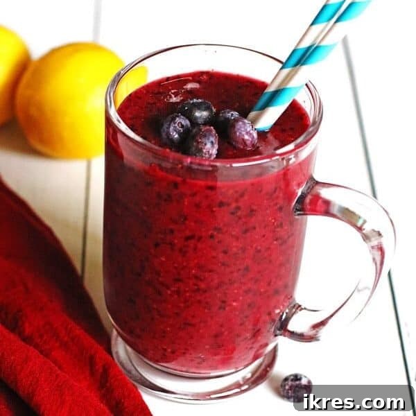 The Art of Freezing Blueberries for Smoothies and Baked Treats 6 Smoothie made with blueberries and lemon in a clear mug sitting on a white table.