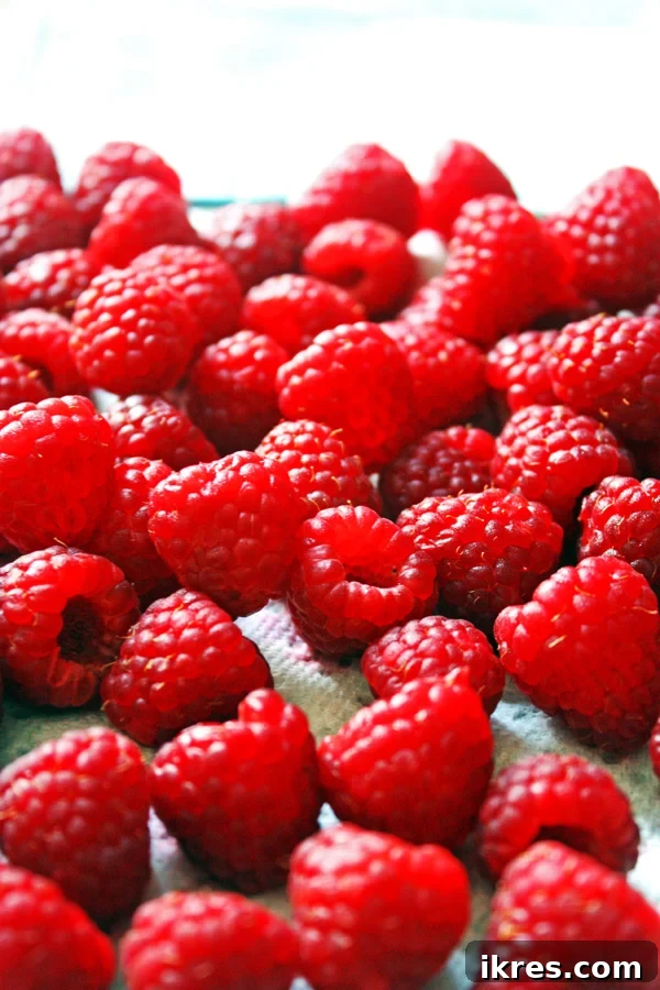 Close-up of fresh raspberries drying on a clean white towel after gentle washing.
