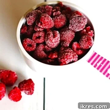 Frozen raspberries in a measuring cup, perfectly flash-frozen for future use.