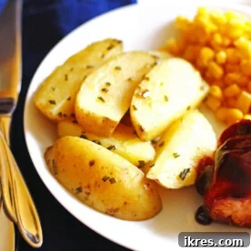 A plate with roasted potato wedges, corn, and bbq chicken.