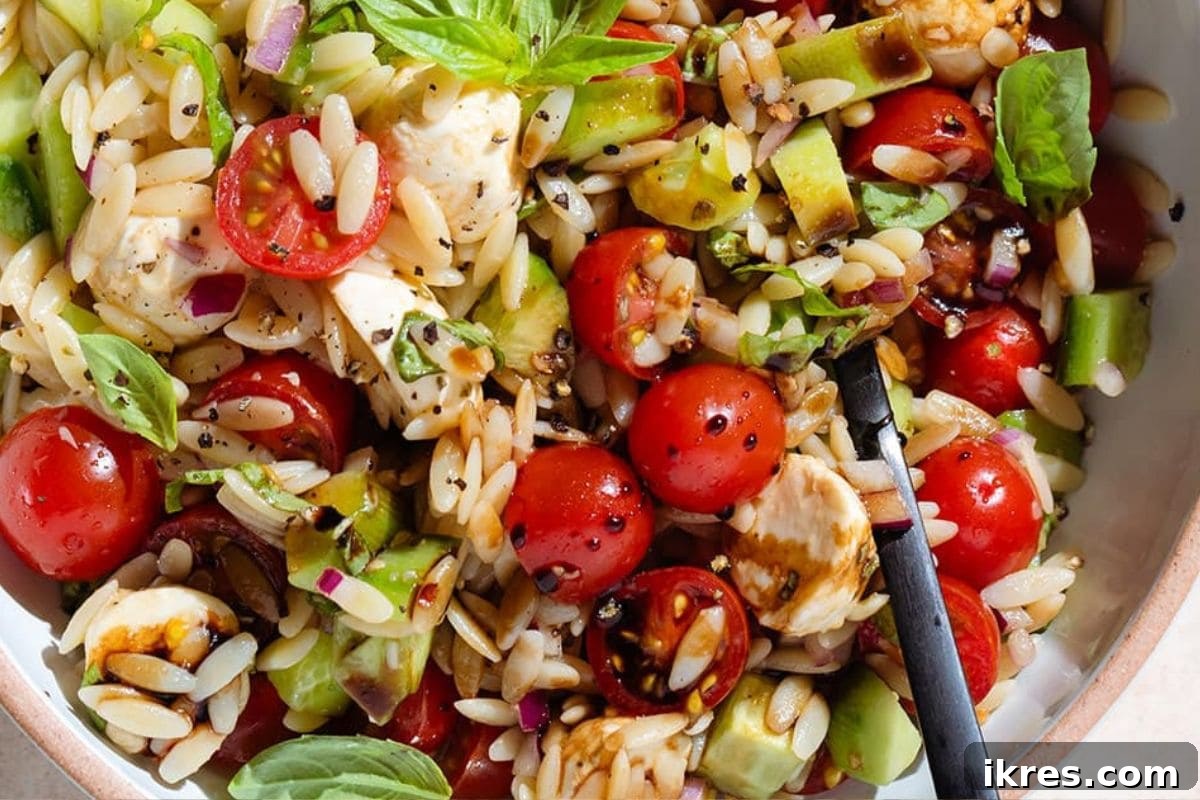 Orzo Caprese Salad with juicy tomatoes, cucumber, and creamy mozzarella