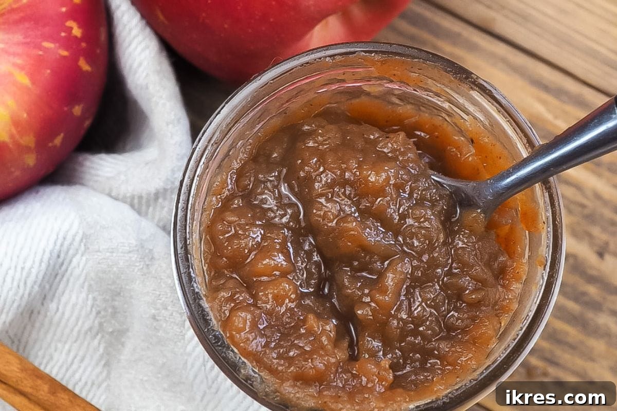 12 Delicious Apple Recipes You'll Absolutely Adore 5 Maple and Bourbon Apple Butter in a glass jar, surrounded by fresh apples and cinnamon sticks