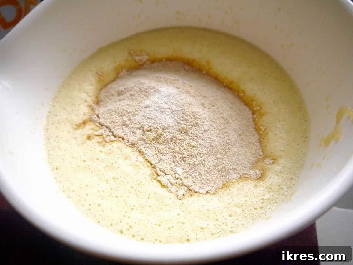 Paleo Gluten-Free Apple Cinnamon Waffles 4 Mixing waffle batter in a bowl with a handheld mixer.