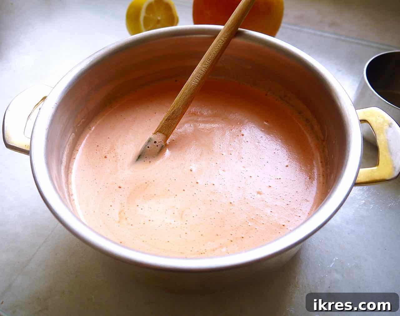Grapefruit juice, coconut cream, and honey simmering in a saucepan.