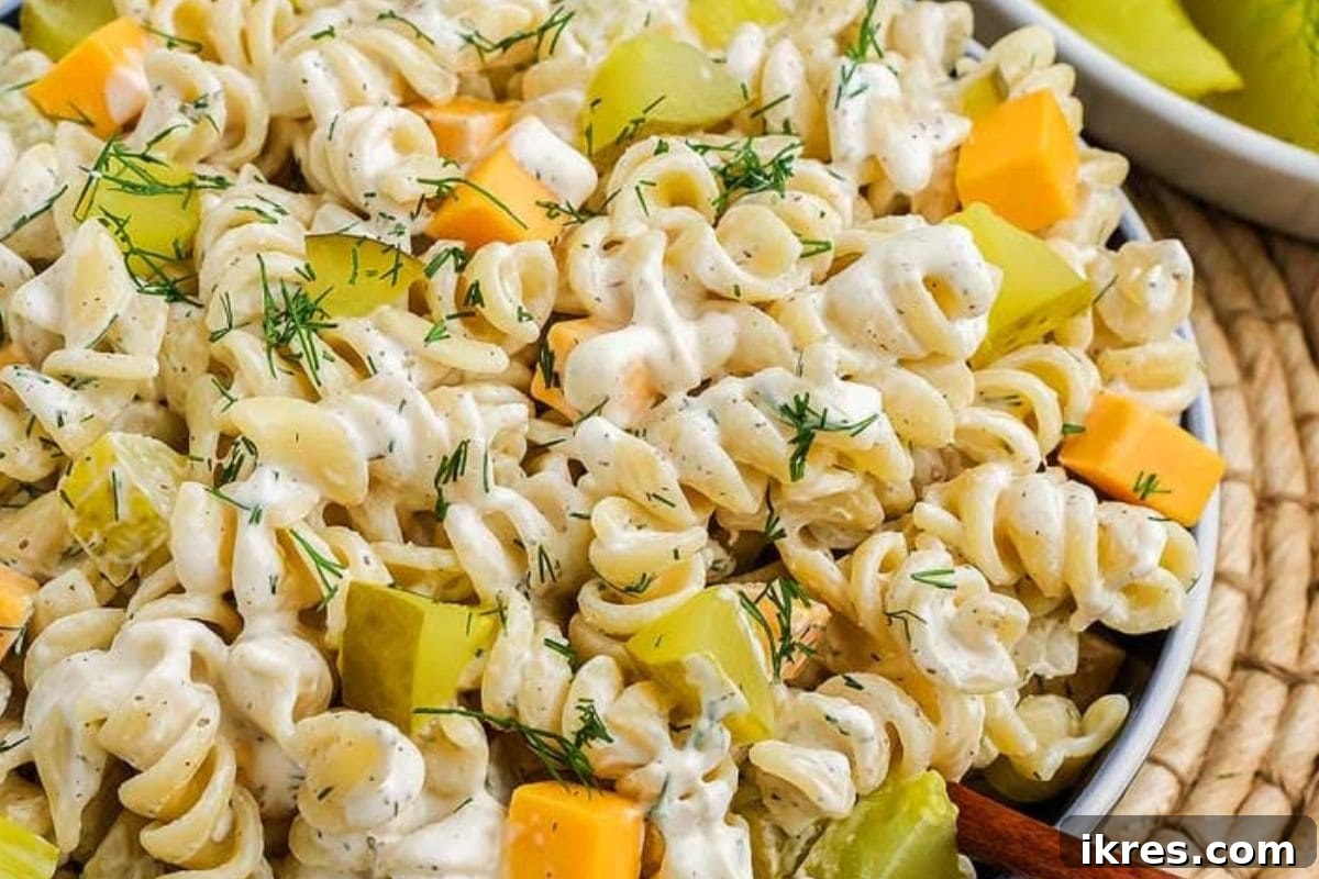 40 Irresistible BBQ Sides 4 A creamy pasta salad loaded with diced dill pickles and fresh dill, served in a white bowl.