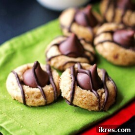 Classic Peanut Butter Kiss Cookies adorned with a chocolate kiss, resting on festive green and red napkins.