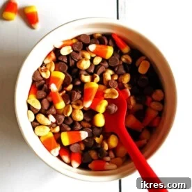 A festive bowl of Candy Corn Party Mix, complete with a red spoon, perfect for fall gatherings.