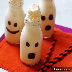 Charming vanilla milkshakes served in clear glasses, artfully decorated to resemble spooky ghosts.