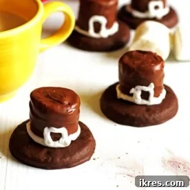 Festive Thanksgiving Cookies, creatively decorated as Pilgrim Hats, set on a pristine white table alongside a glass of milk.