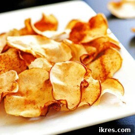 A plate piled high with crispy cinnamon apple chips.