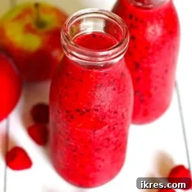 Two jars filled with a healthy and vibrant apple berry smoothie.