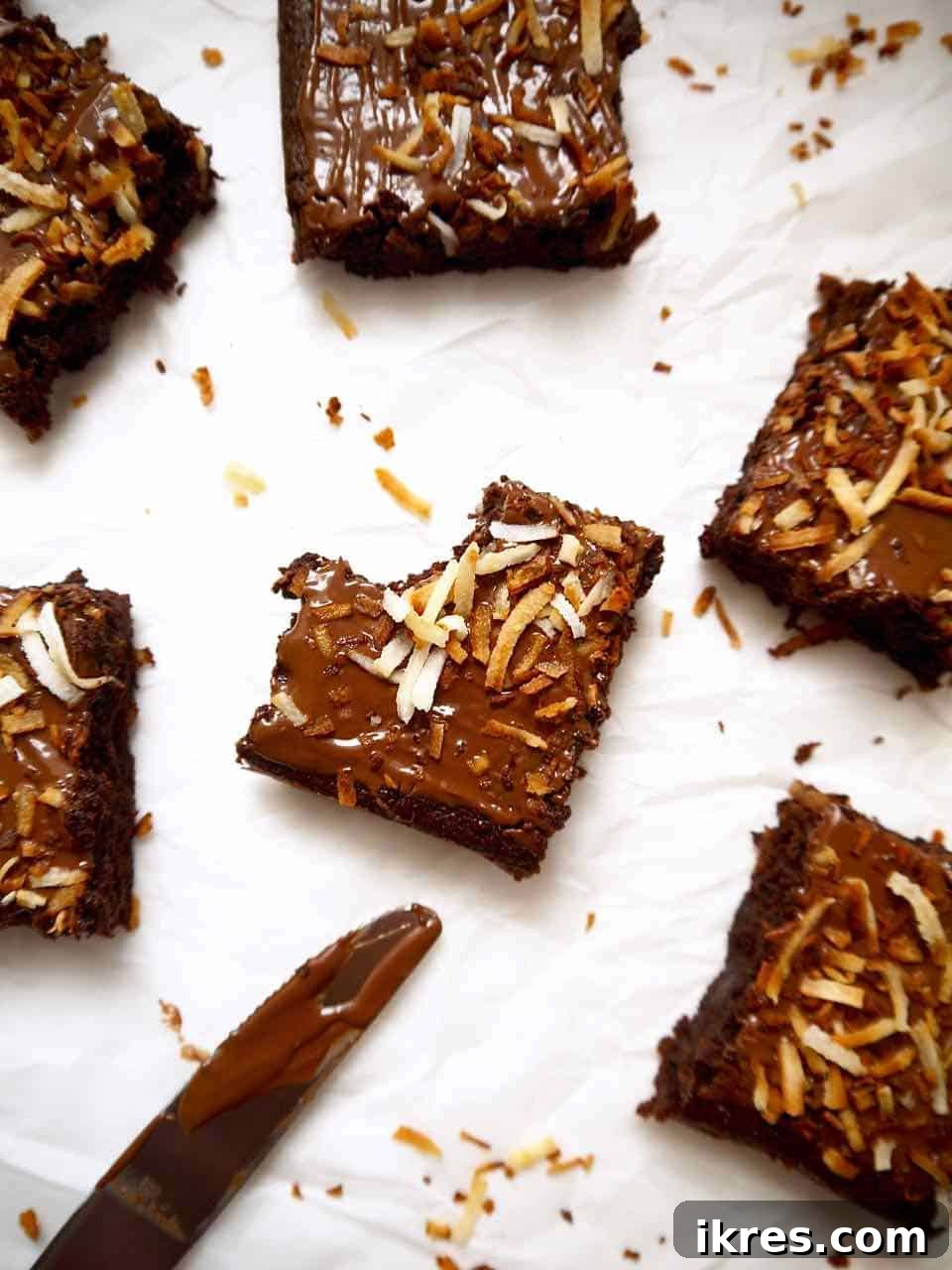 Gluten-Free Toasted Coconut Cloud Brownies 2 A bite taken out of a Gluten-free Toasted Coconut Brownie, showing its fudgy interior and crunchy coconut topping.