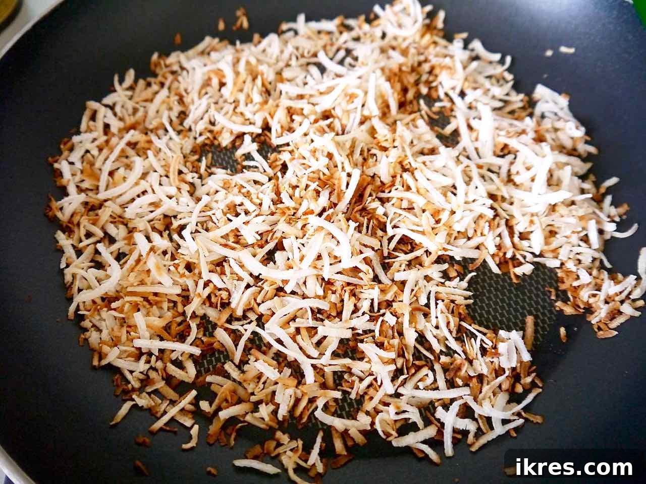 Gluten-Free Toasted Coconut Cloud Brownies 4 Unsweetened shredded coconut being toasted to a golden-brown perfection in a frying pan.