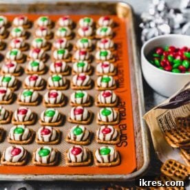 Christmas Pretzel Hugs with melted Hershey's Kisses and holiday M&M's, a simple and sweet-salty treat.