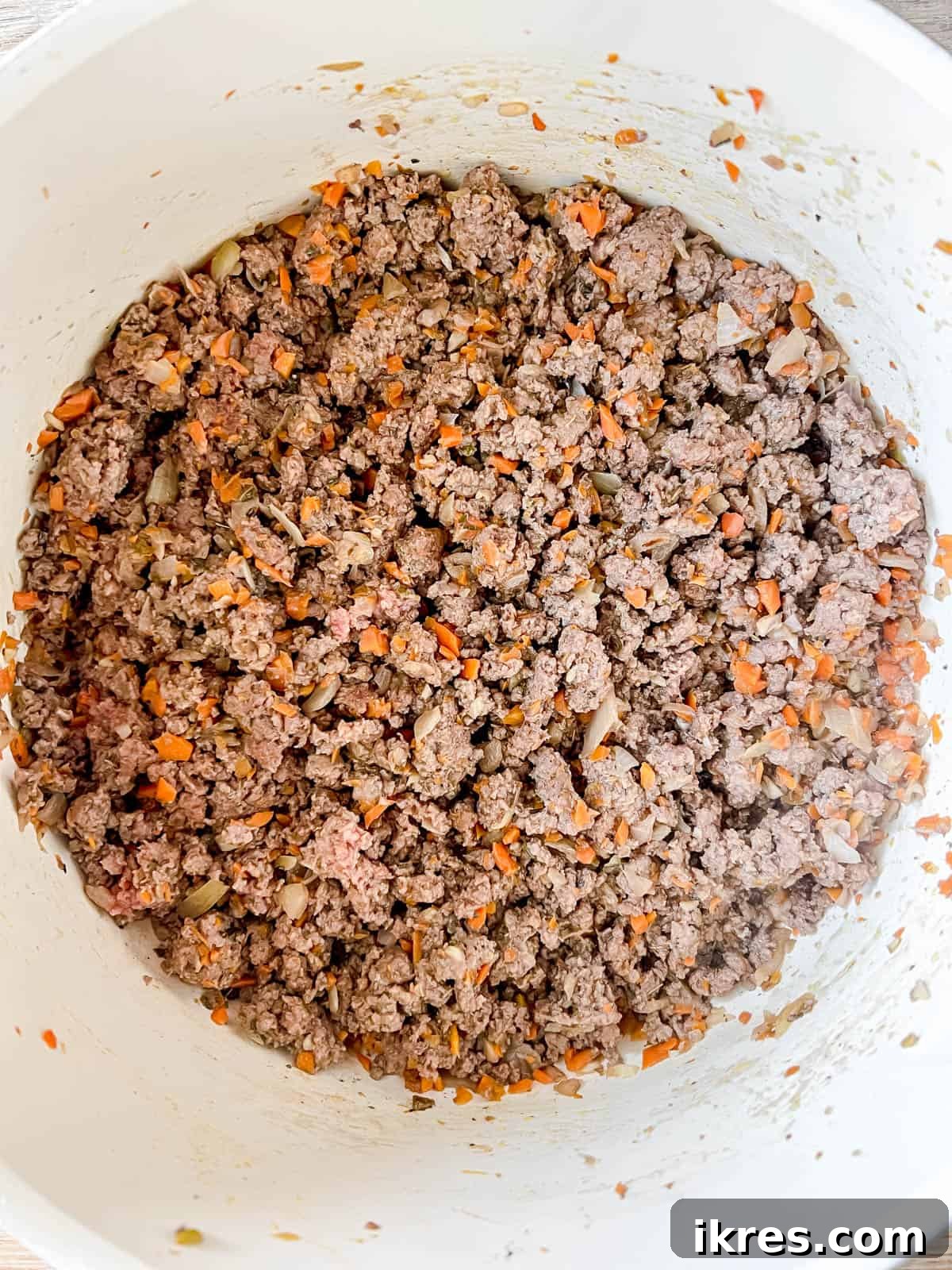 Perfectly browned ground bison, separated into fine crumbles, filling the bottom of a large pan, ready for the next ingredients.