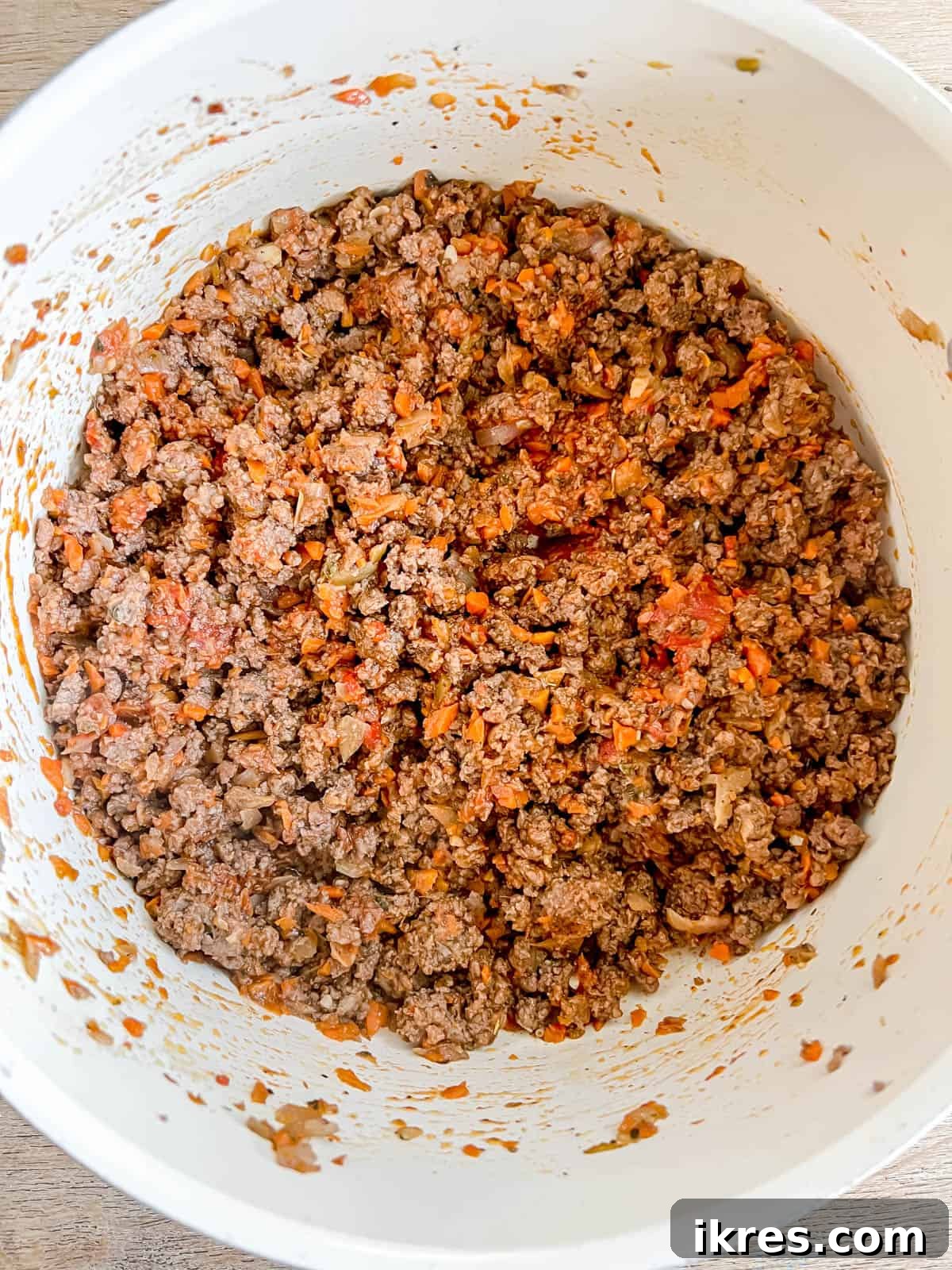 A rich dollop of tomato paste stirred into the browned bison and aromatics, deepening the color and flavor of the sauce base.
