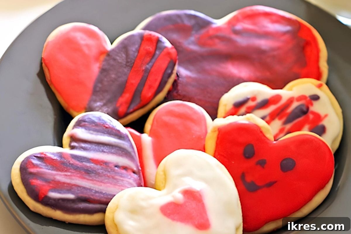 20 Essential Cookie Classics 20 Heart Sugar Cookies beautifully frosted with pink and white icing, adorned with sprinkles.