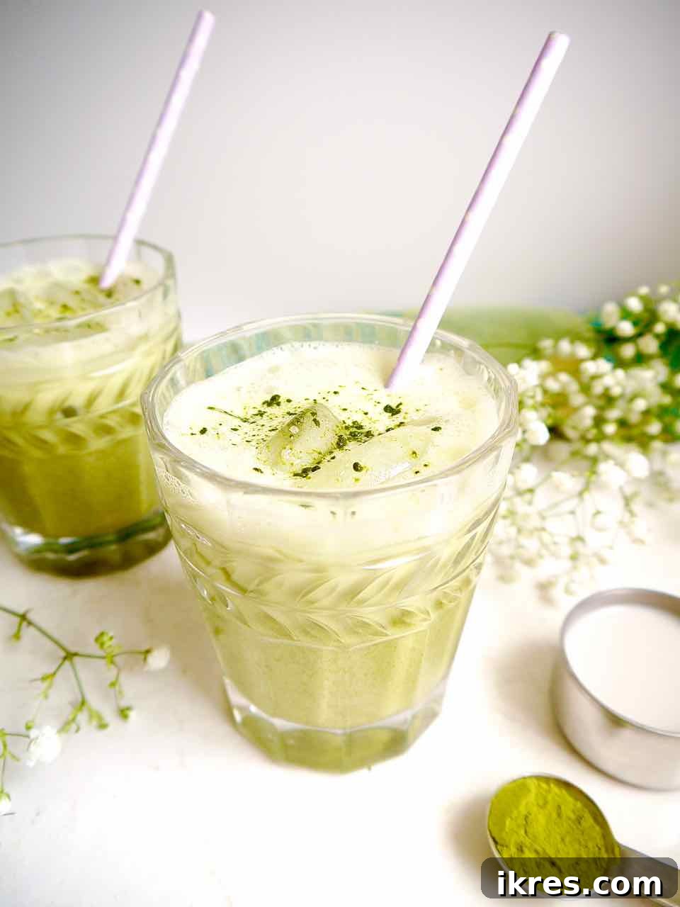 Creamy Vegan Iced Almond Matcha Latte 11 A close-up of a glass of iced almond milk matcha latte, showing the ice cubes and creamy texture.