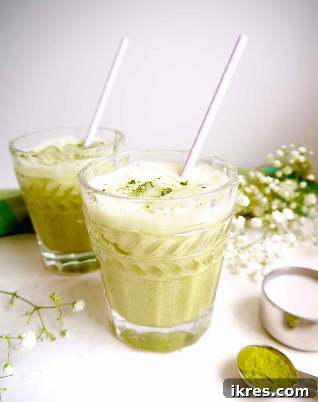 Creamy Vegan Iced Almond Matcha Latte 3 Two glasses of iced almond milk matcha latte, showcasing the beautiful green color and creamy texture.