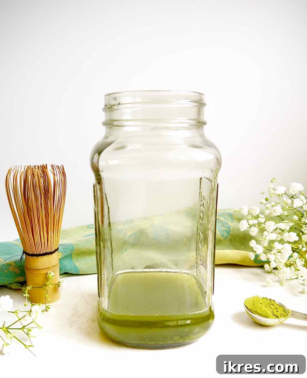Creamy Vegan Iced Almond Matcha Latte 7 Matcha tea powder thoroughly mixed into hot water within a mason jar.