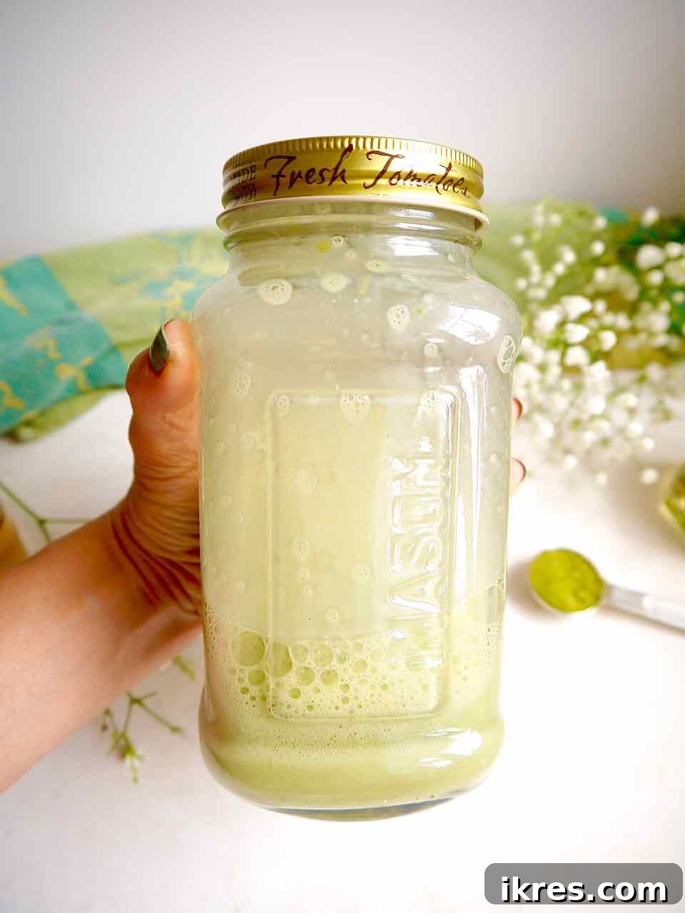 Creamy Vegan Iced Almond Matcha Latte 9 Almond milk mixed into the matcha and honey mixture in a mason jar.