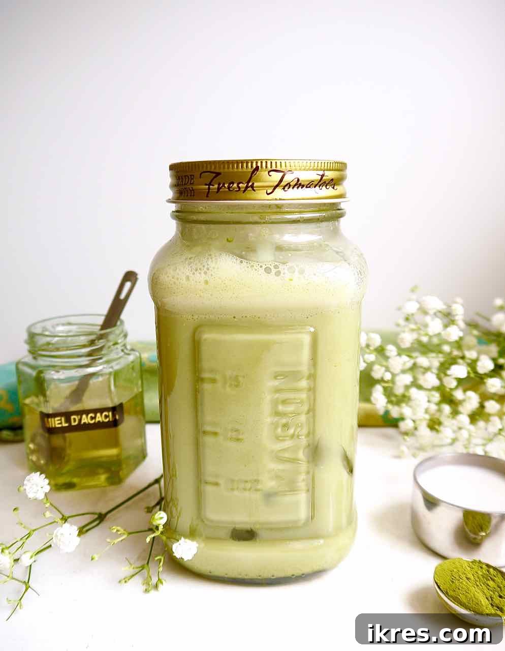 Creamy Vegan Iced Almond Matcha Latte 10 A mason jar filled with the iced almond milk matcha latte and ice.