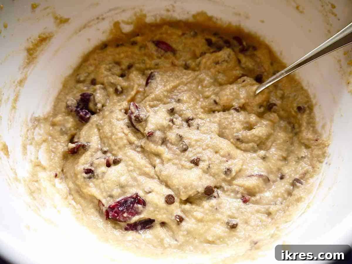 Pure Paleo Cherry Banana Loaf 4 A bowl filled with the prepared cherry banana bread batter, showing chunks of cherries and chocolate chips.